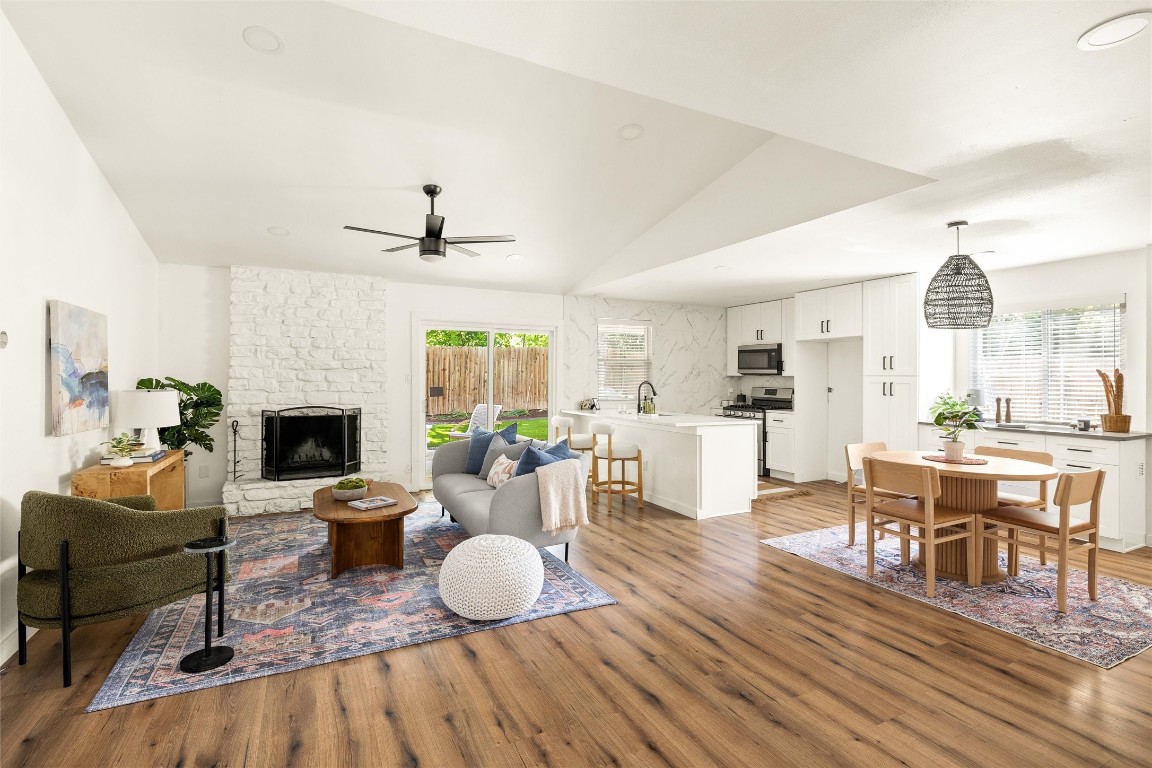 a living room with furniture a fireplace and a large window