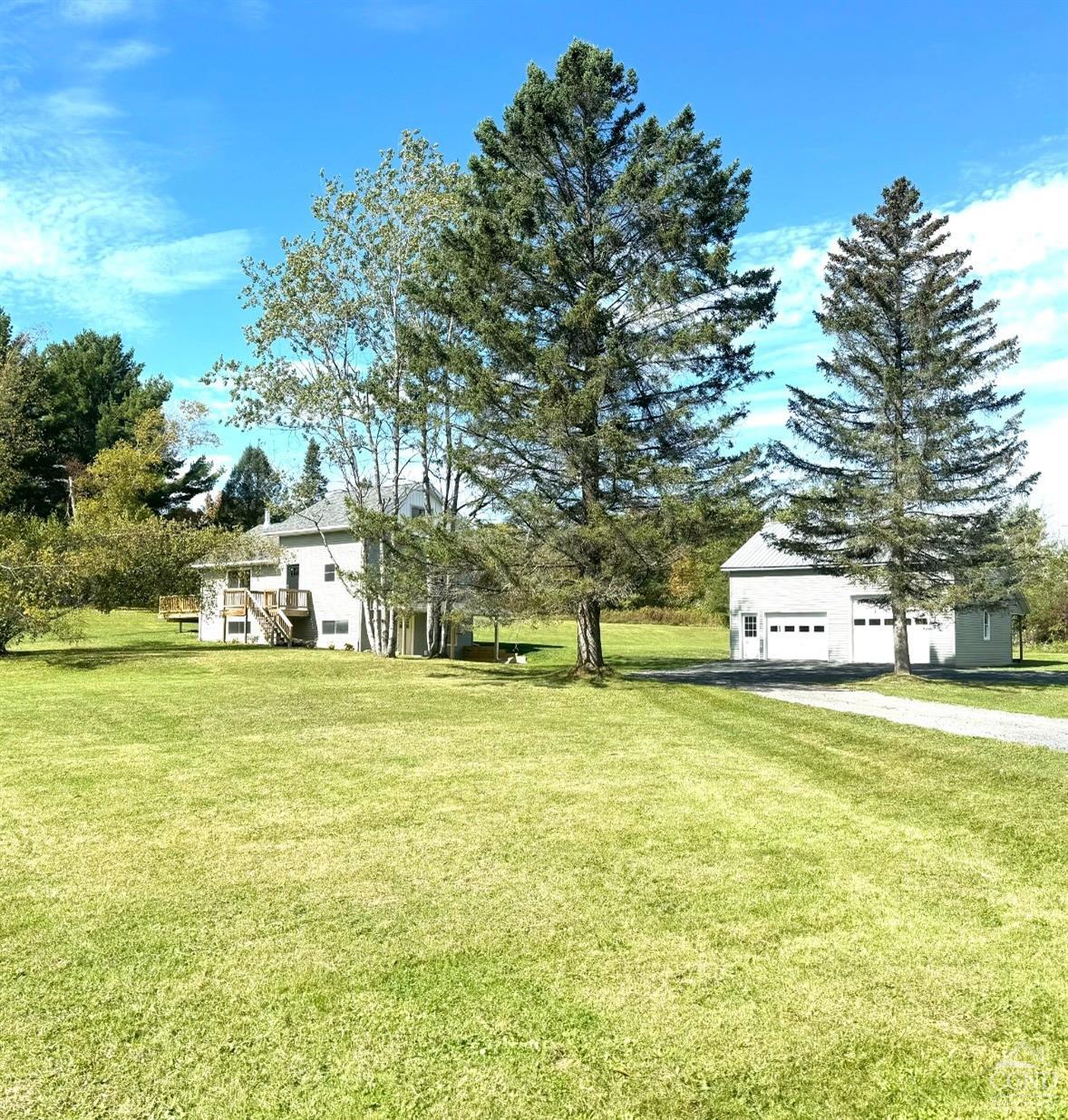 a front view of a house with a yard and trees