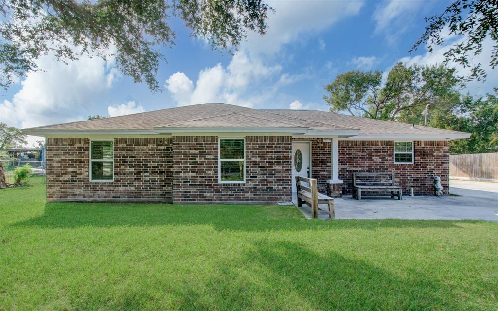 a view of a house with a yard and sitting area