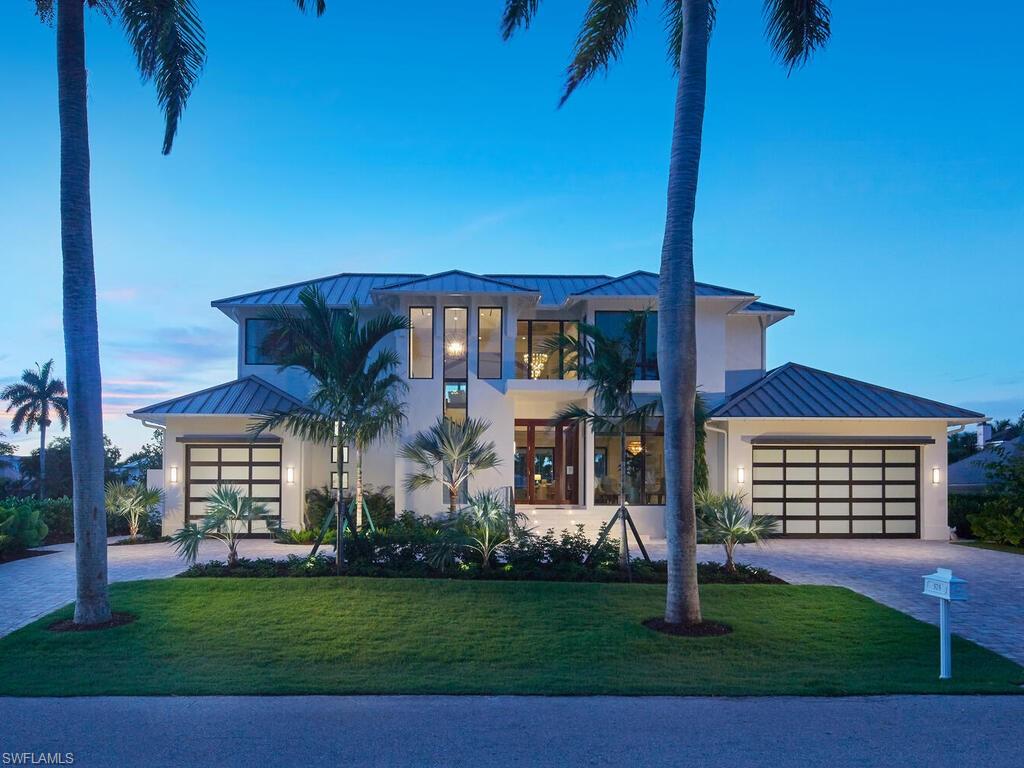 View of front of house featuring a garage and a lawn