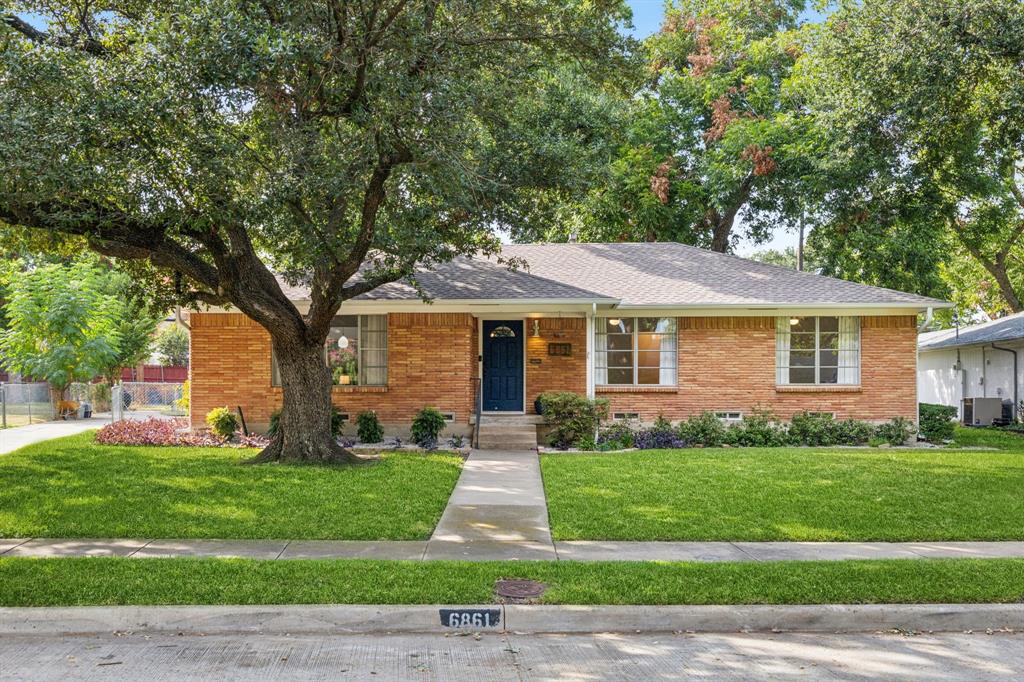 a front view of a house with a garden and yard