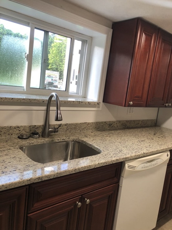 a kitchen with granite countertop a sink and a window