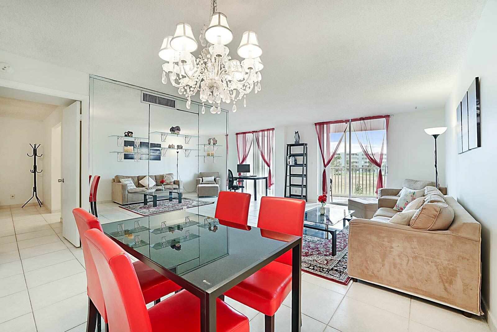 a living room with furniture a chandelier and a dining table