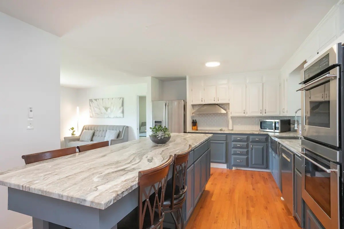 a kitchen with granite countertop a sink stove and refrigerator