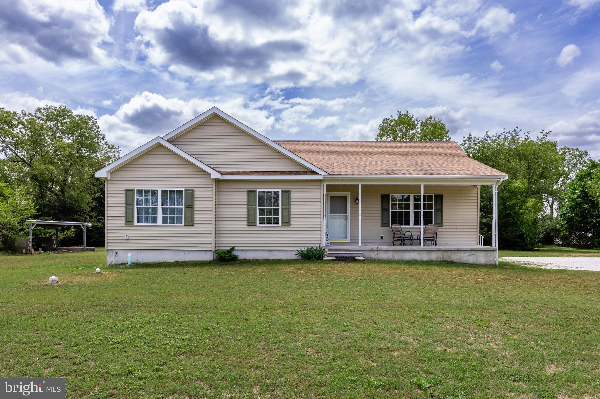 a front view of a house with a garden and yard