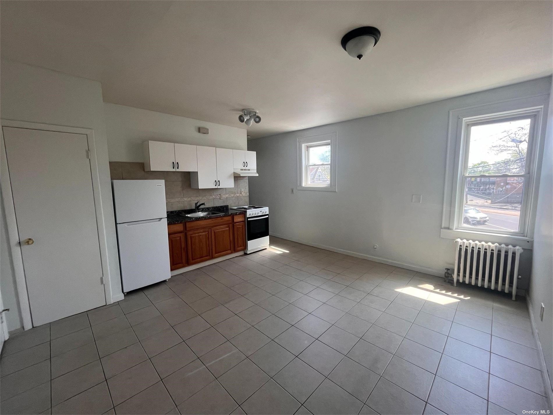 a view of kitchen with cabinets and refrigerator