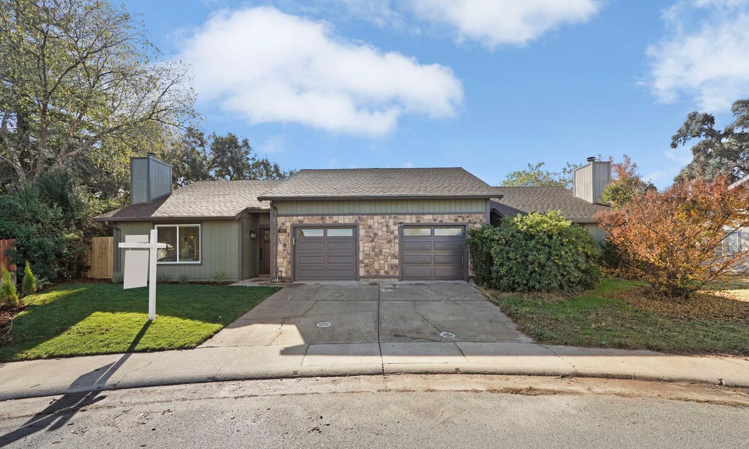 a front view of a house with a yard and a garage