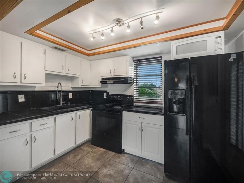 a kitchen with granite countertop a sink stainless steel appliances and cabinets