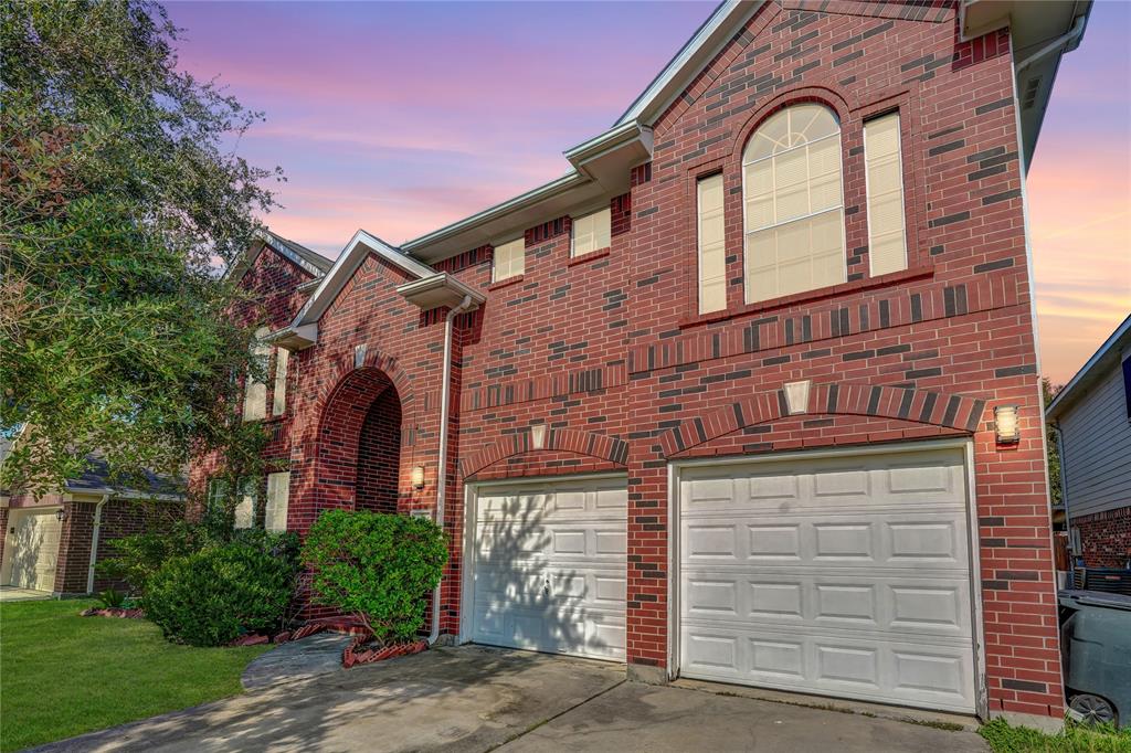 front view of a brick house with a small yard