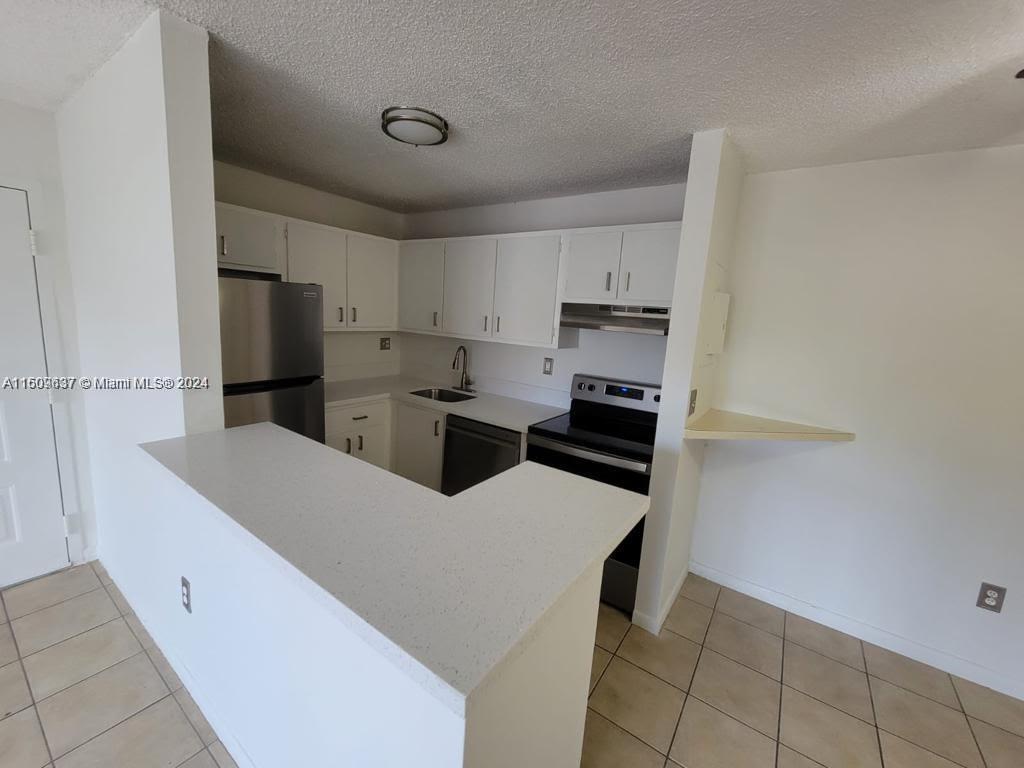 a kitchen with stainless steel appliances a refrigerator sink and cabinets