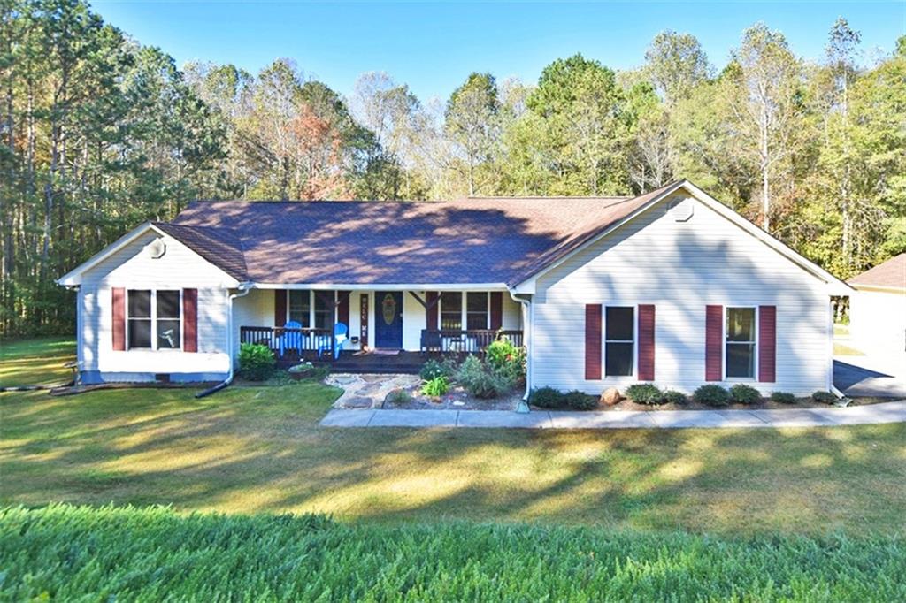 a front view of house with yard and trees in the background