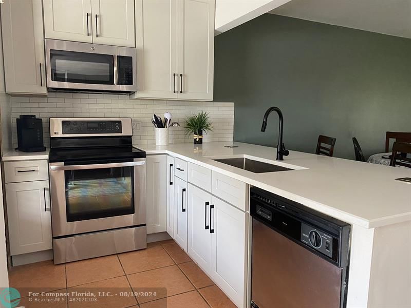 a kitchen with stainless steel appliances a stove sink and cabinets