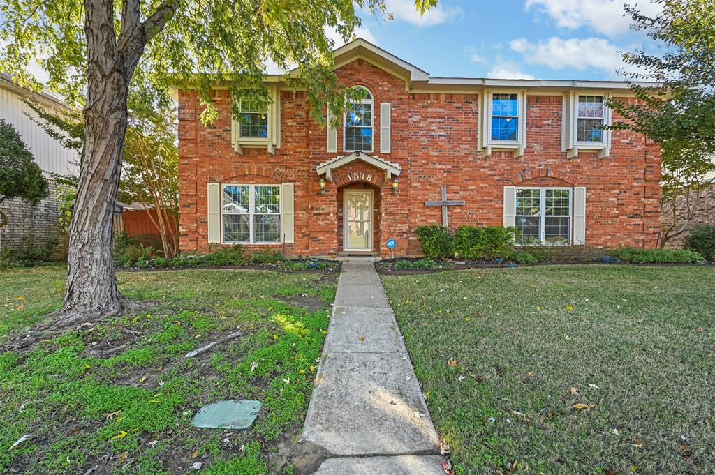 front view of a brick house with a yard