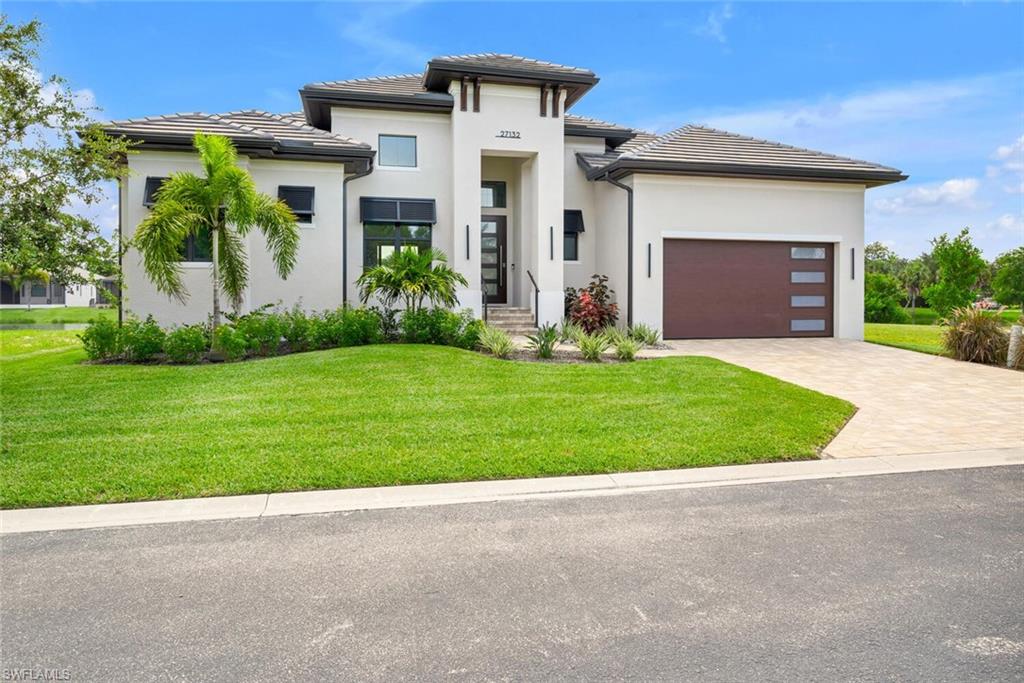 a front view of a house with a yard and garage