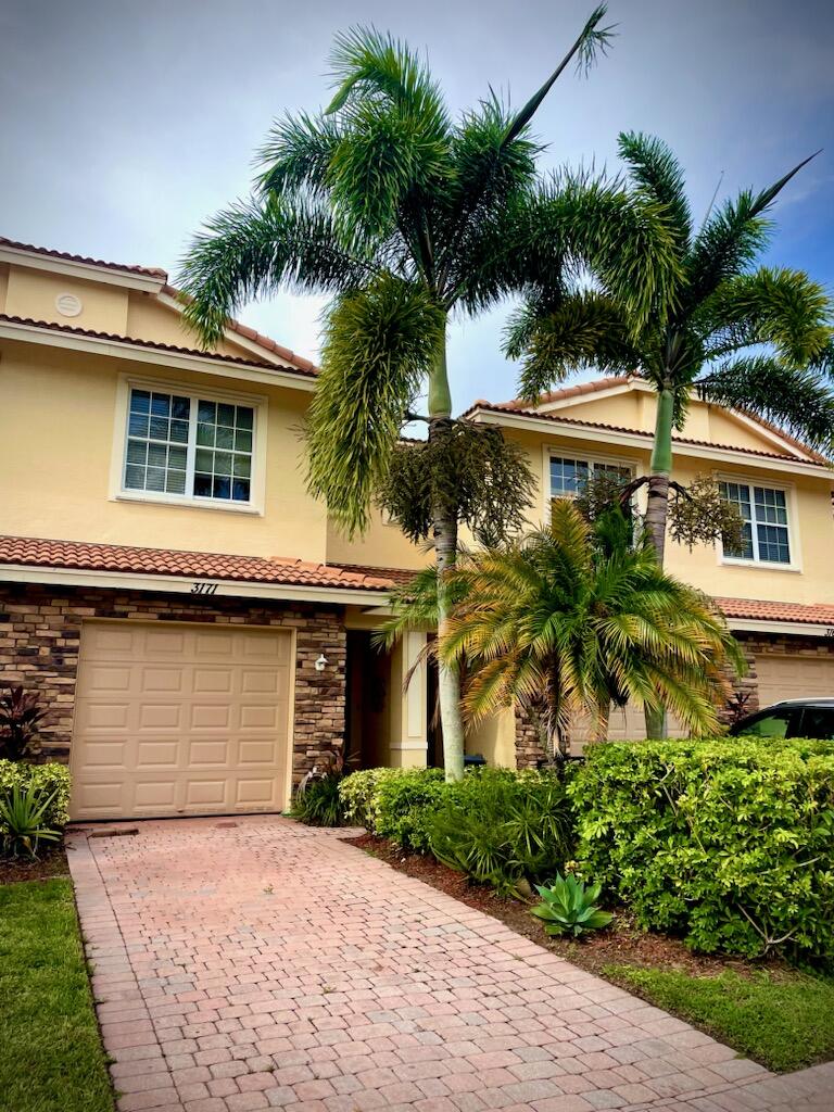 a front view of a house with a garden