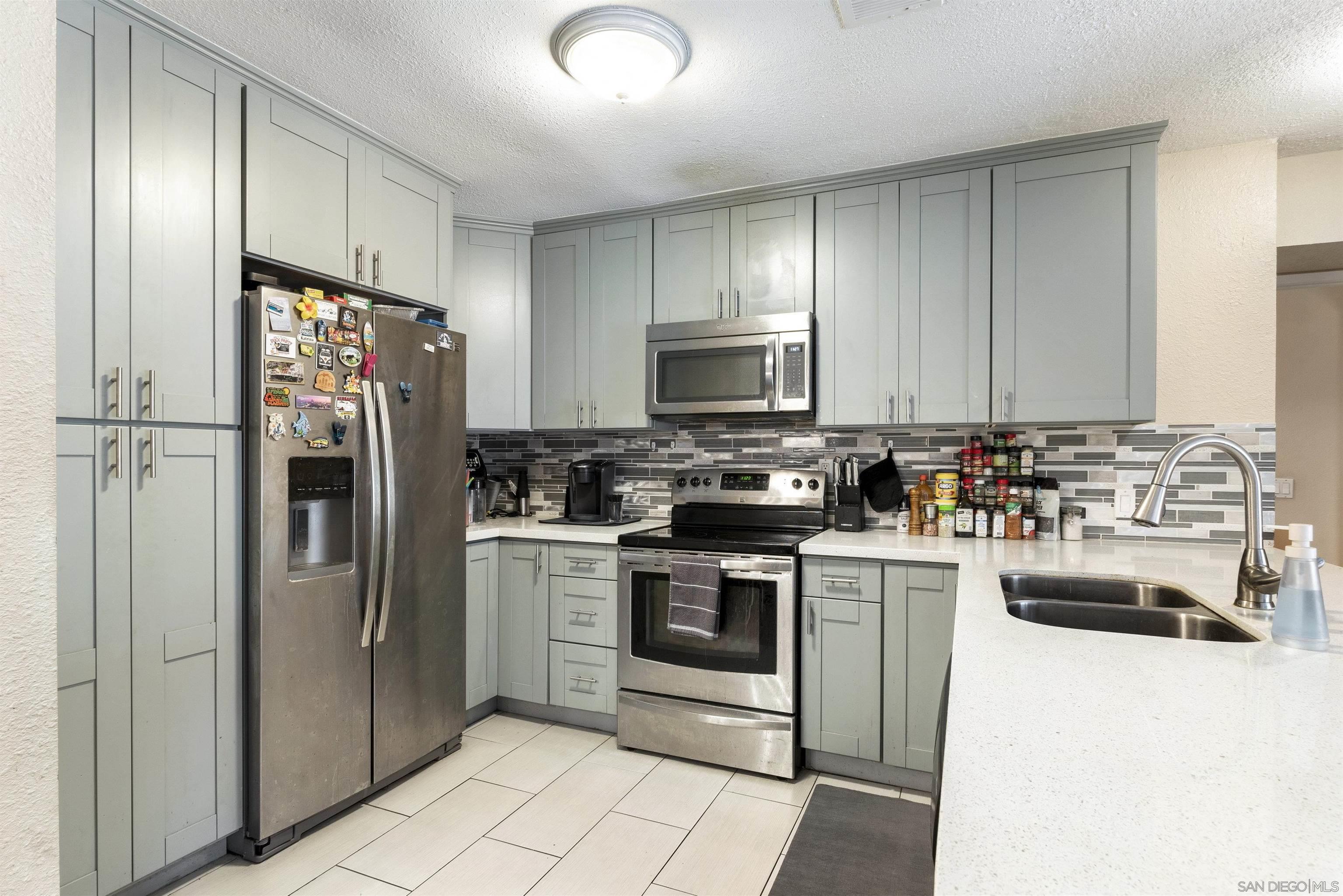 a kitchen with refrigerator a microwave a stove and cabinets