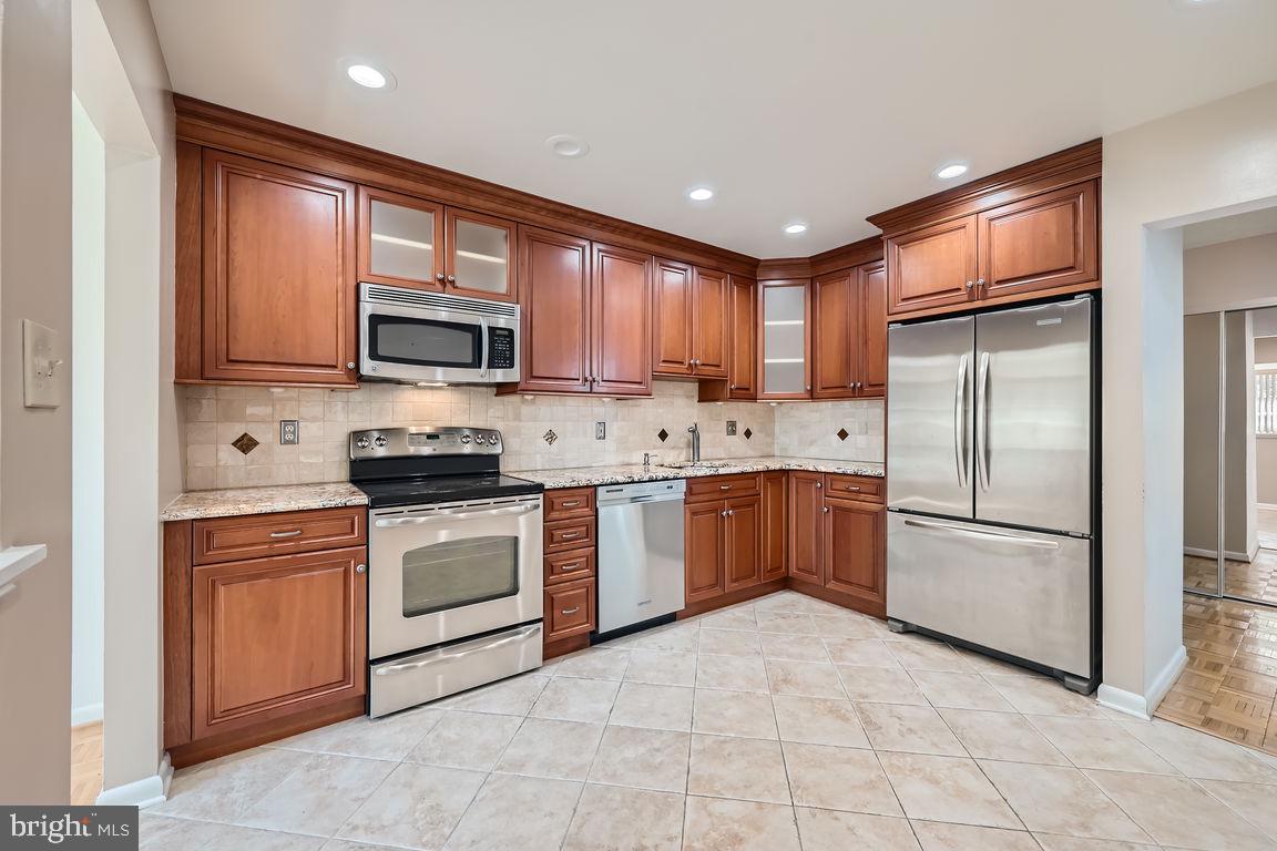 a kitchen with a refrigerator stove top oven a sink and dishwasher