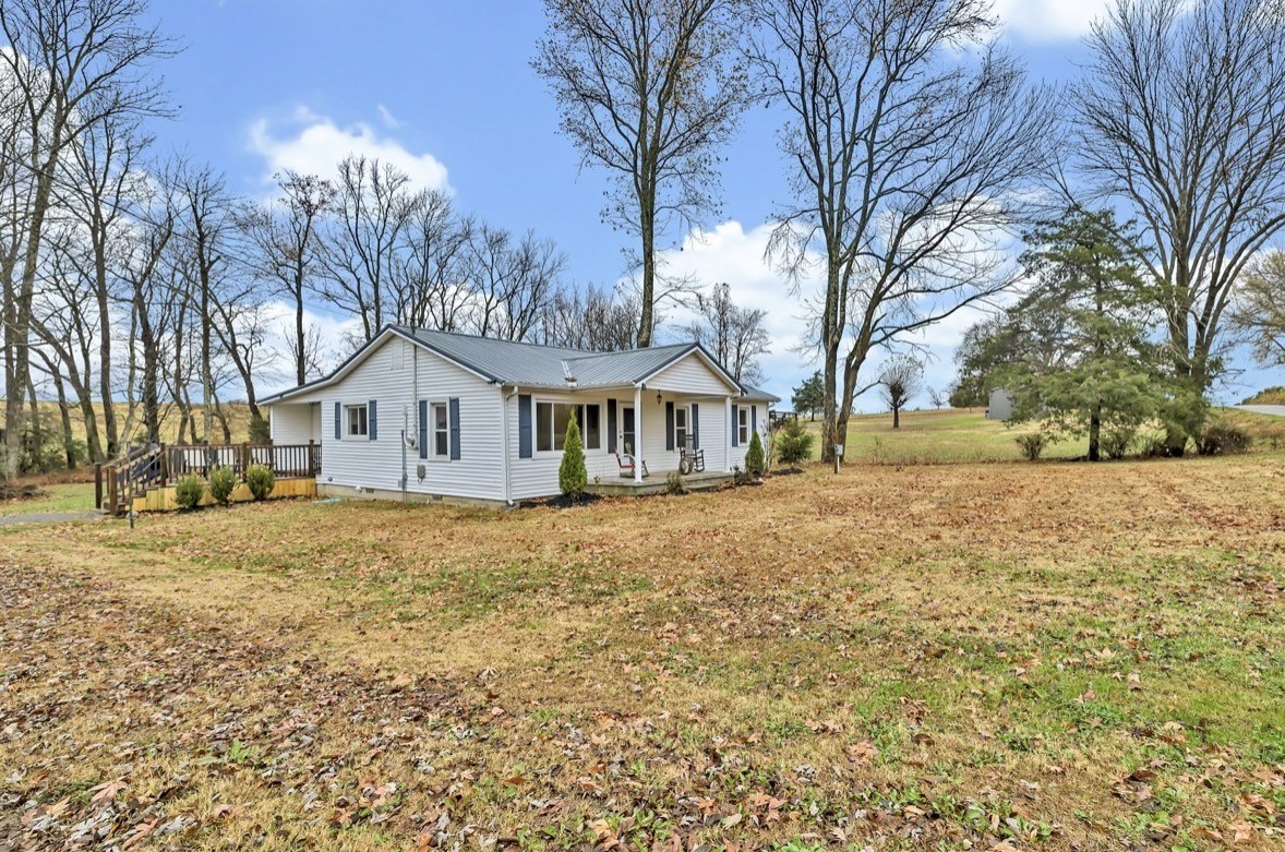 a front view of a house with a yard and trees