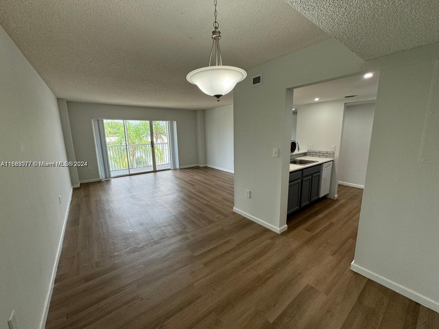 a view of a kitchen with wooden floor and a ceiling fan