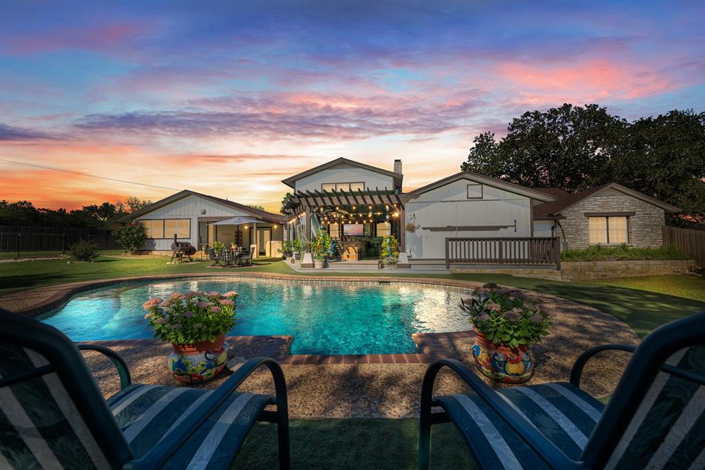 a view of a house with backyard and sitting area