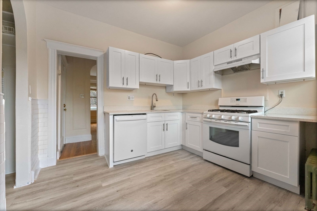 a kitchen with granite countertop white cabinets and white appliances