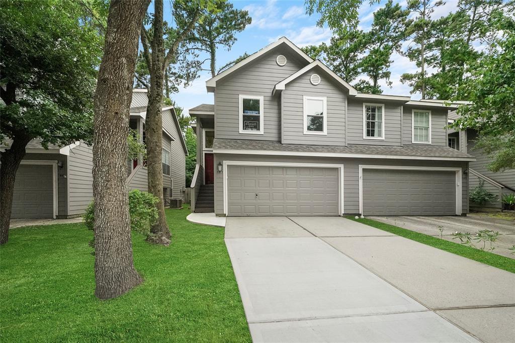 a front view of a house with a garden and trees