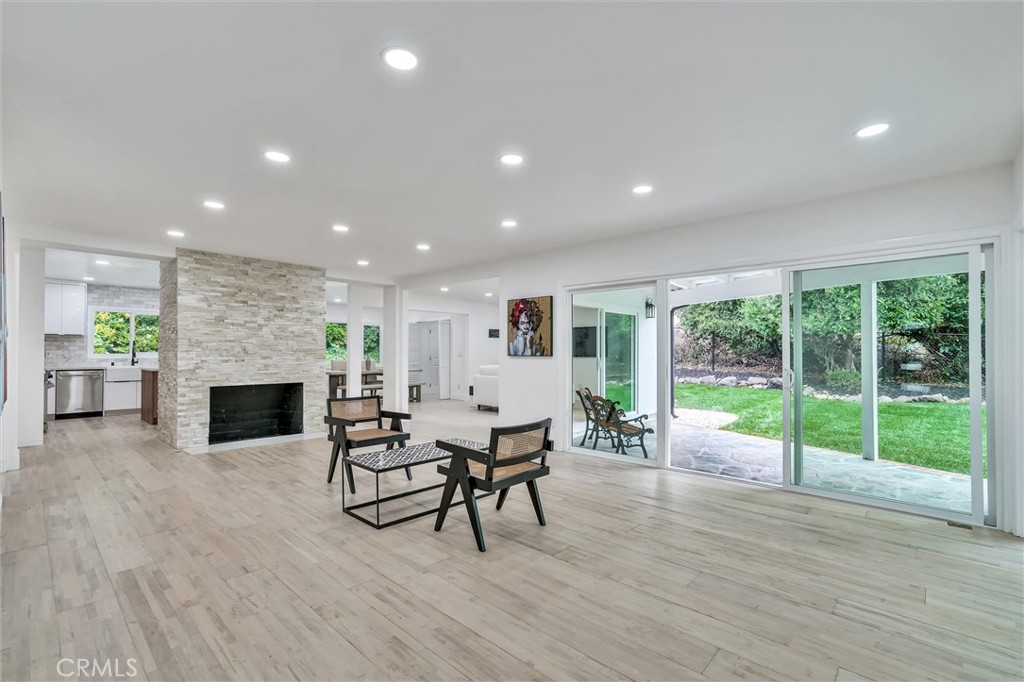 a living room with furniture a fireplace and a floor to ceiling window