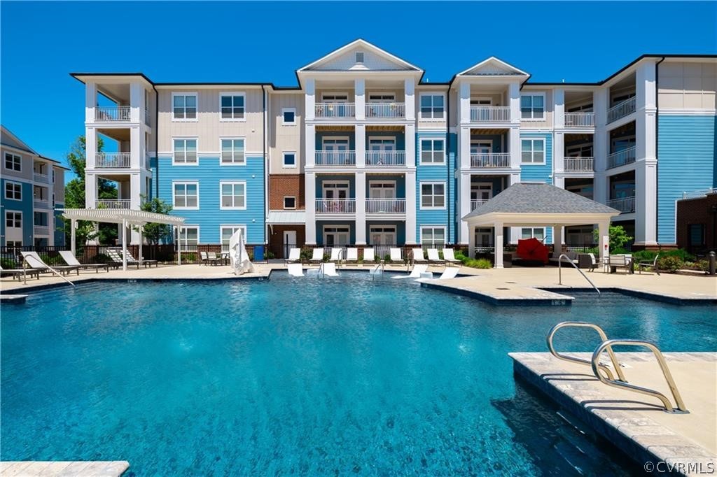 a front view of a building with swimming pool and porch