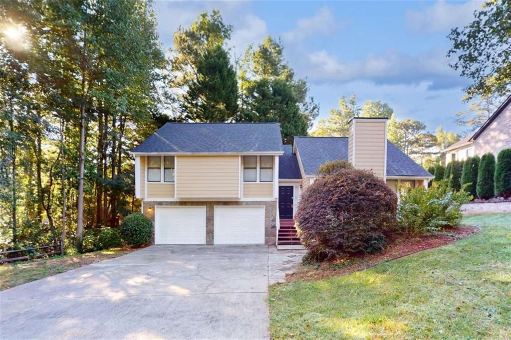 a front view of house with yard and trees in the background