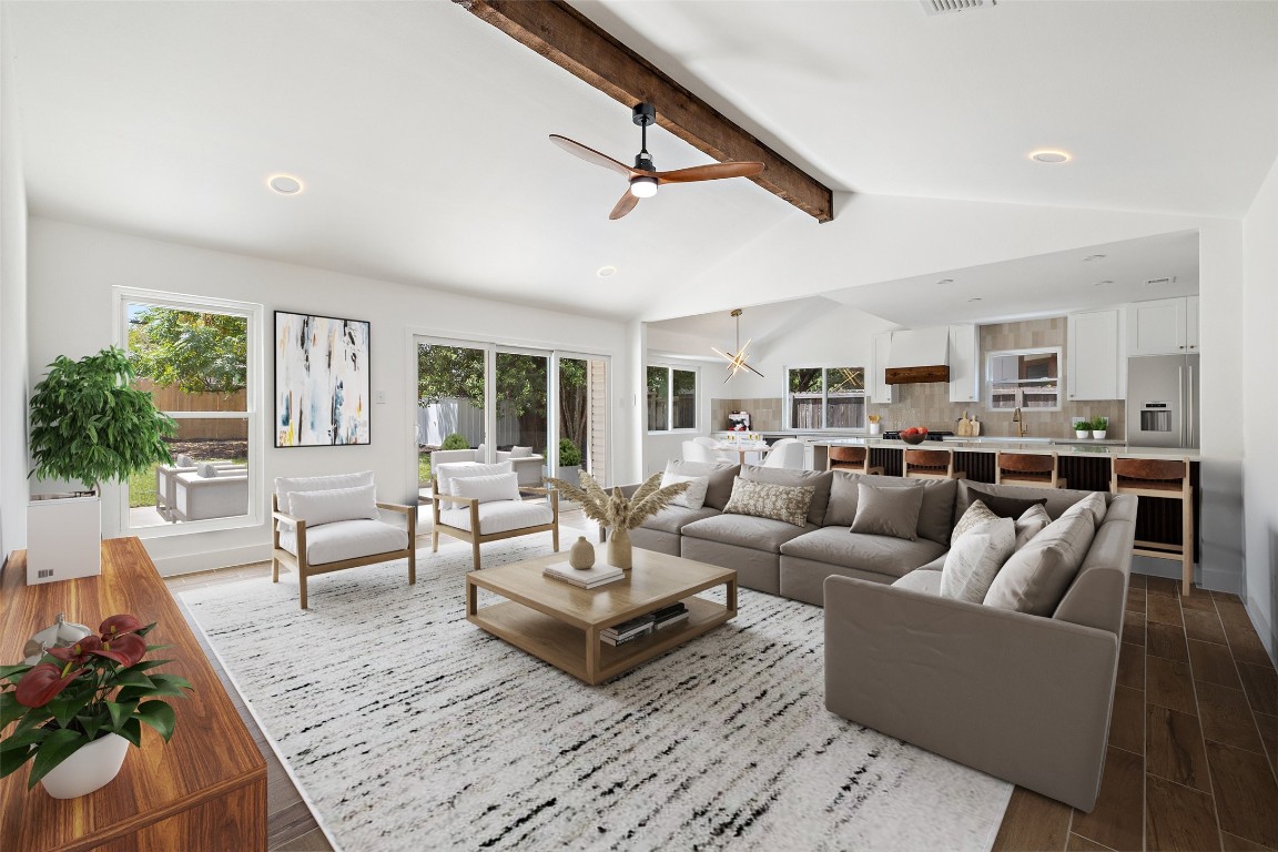 a living room with furniture kitchen view and a large window