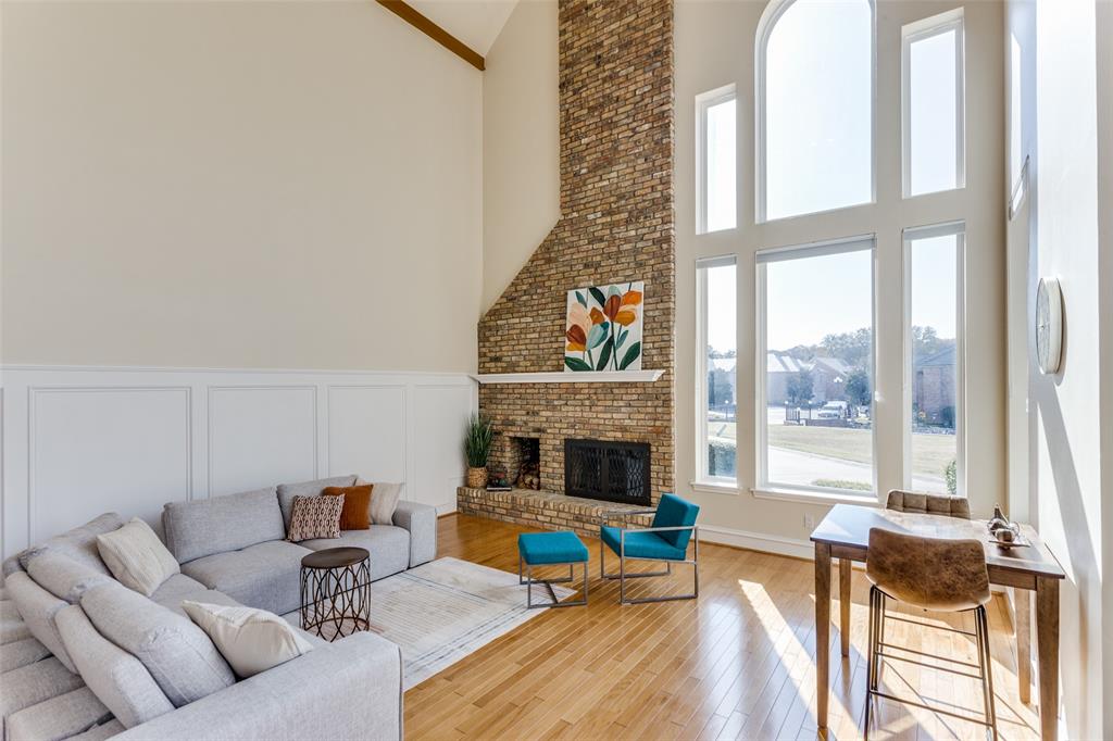 a living room with furniture a fireplace and a floor to ceiling window