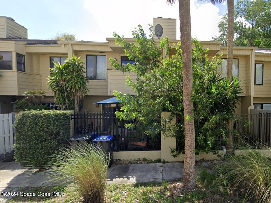 a view of house with a yard and potted plants