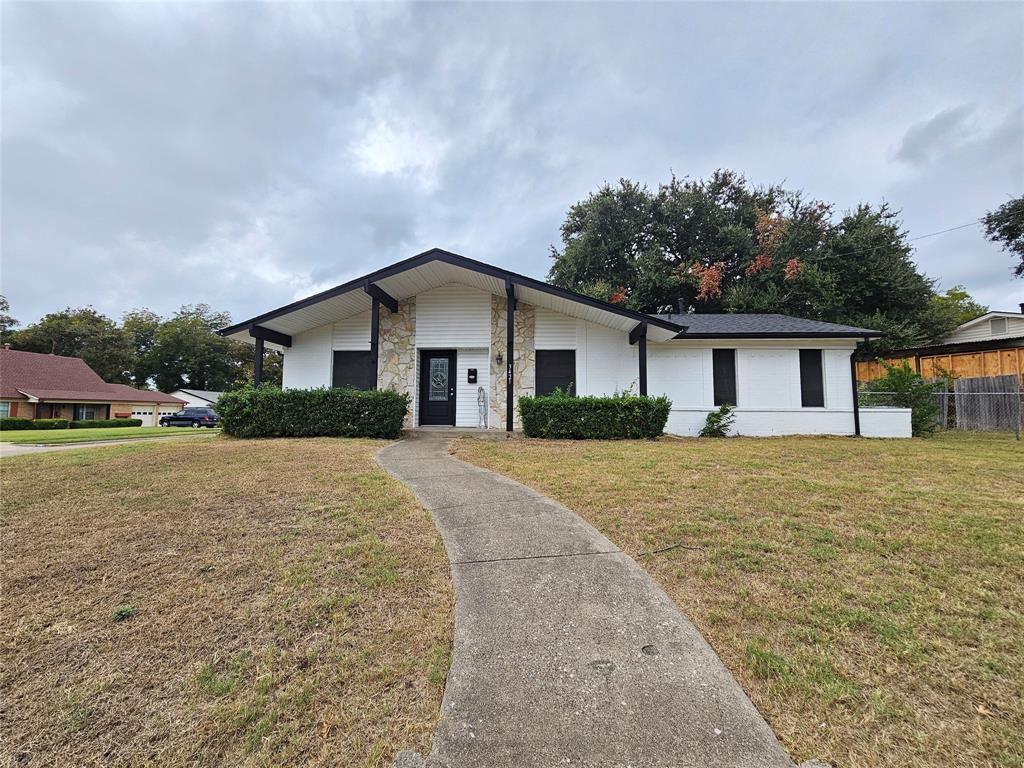 a front view of house with yard and trees around