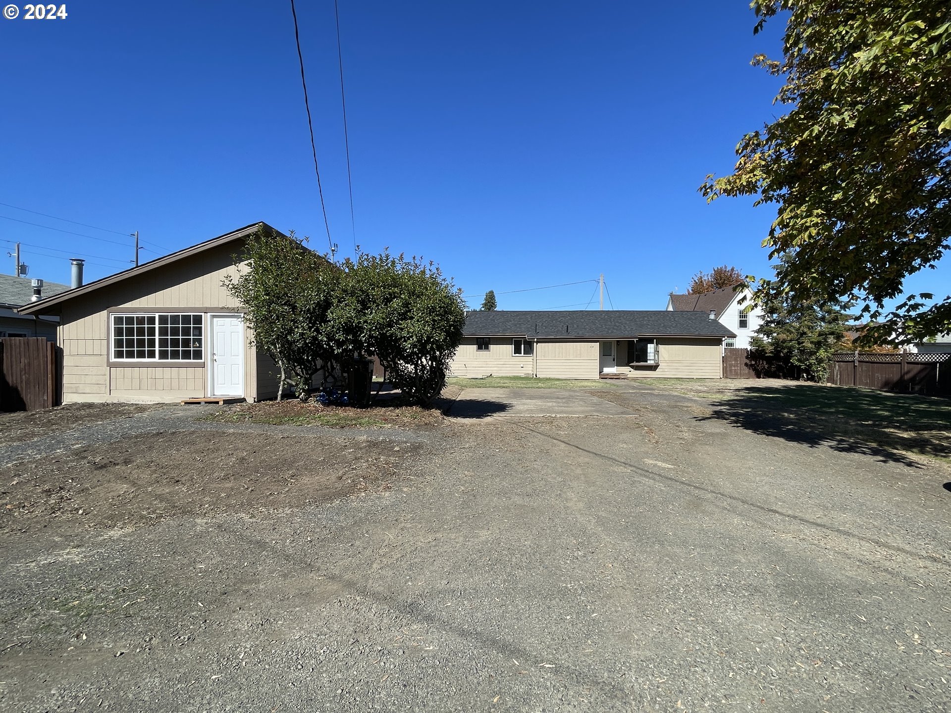 a view of a house with a yard and potted plants