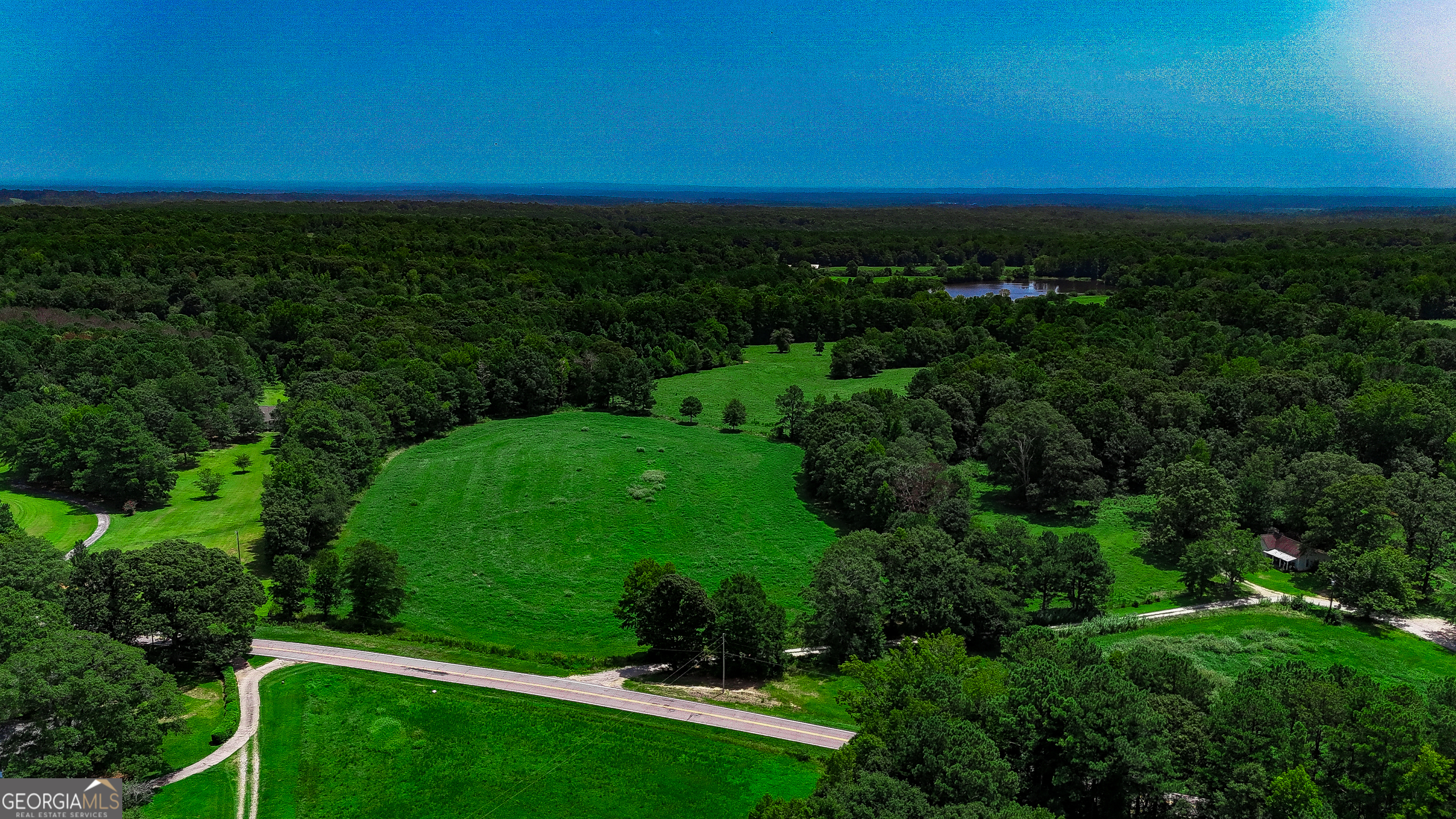 an aerial view of green landscape with trees houses and mountain view