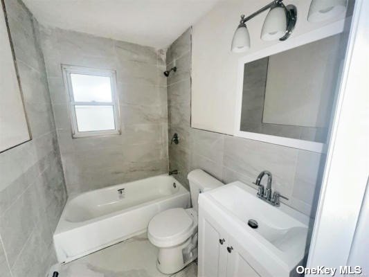 a white bath tub sitting next to a white sink and a toilet