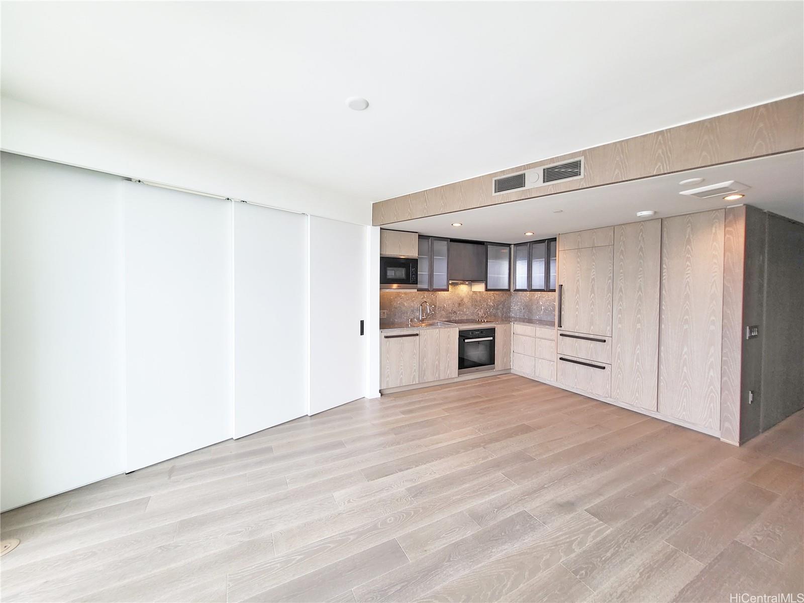 a view of an empty room with a kitchen