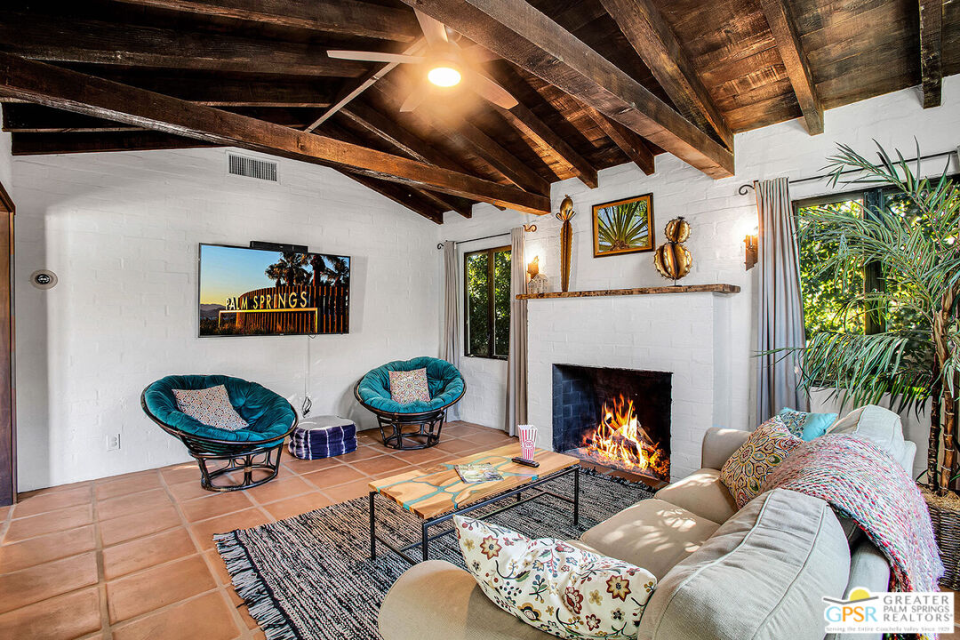 a living room with a couch a fireplace and a potted plant