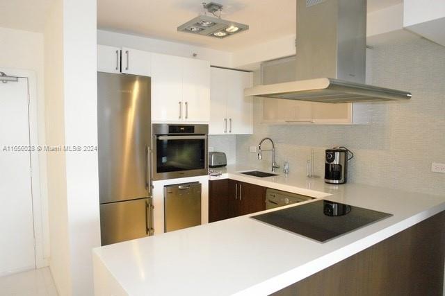 a kitchen with a sink a microwave a refrigerator and cabinets