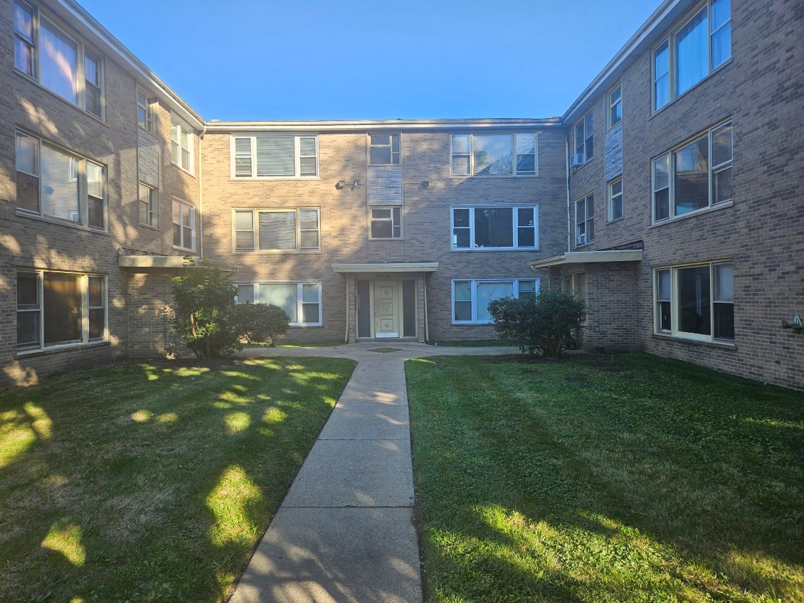 a view of a brick building next to a yard