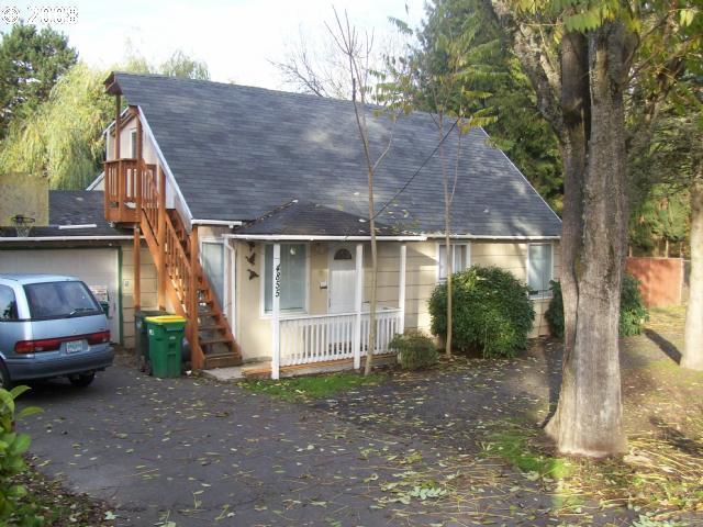 a view of a house that has a car parked beside it