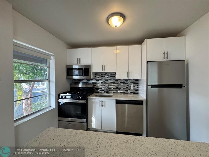 a kitchen with stainless steel appliances a refrigerator stove and microwave