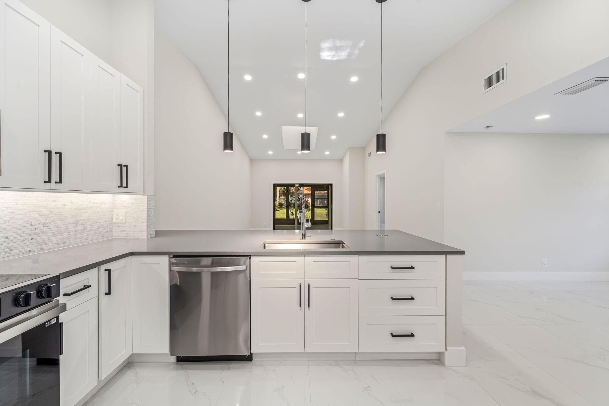 a kitchen with white cabinets and sink