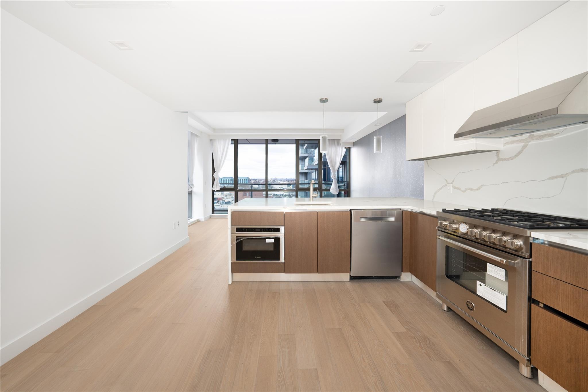 a kitchen with stainless steel appliances granite countertop a stove a sink and a refrigerator