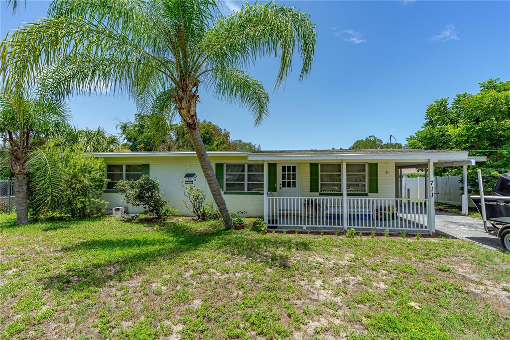 a view of house with backyard and outdoor seating