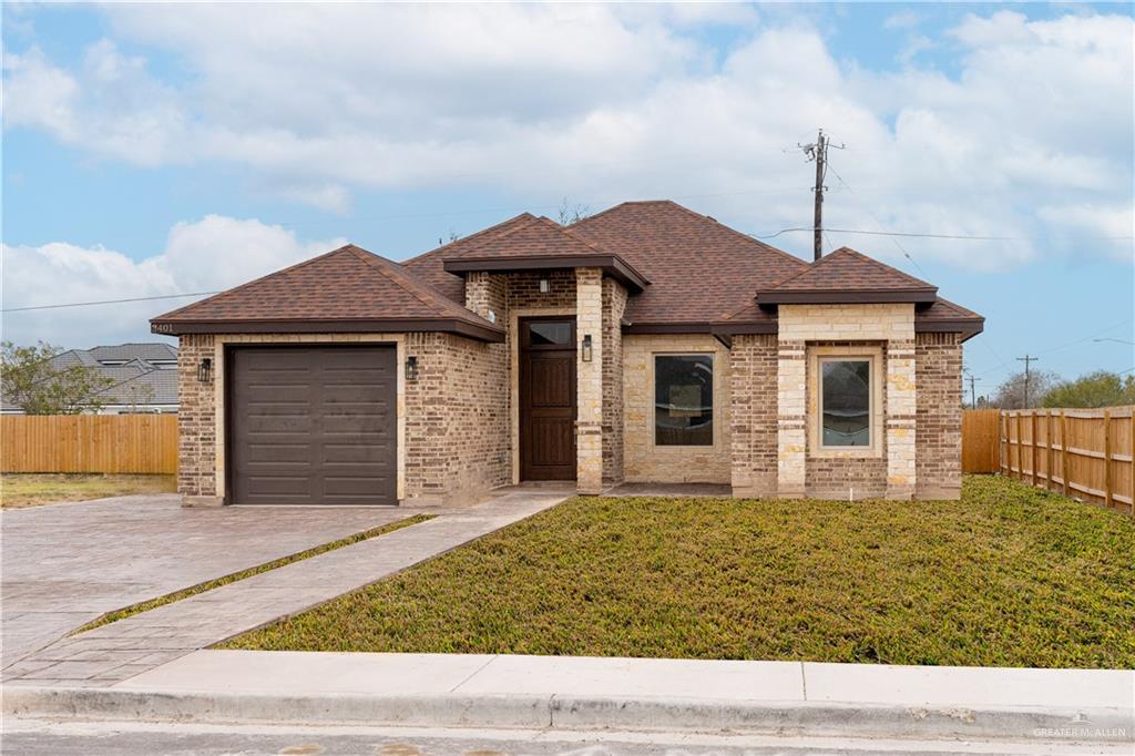 View of front of house with a front yard and a garage