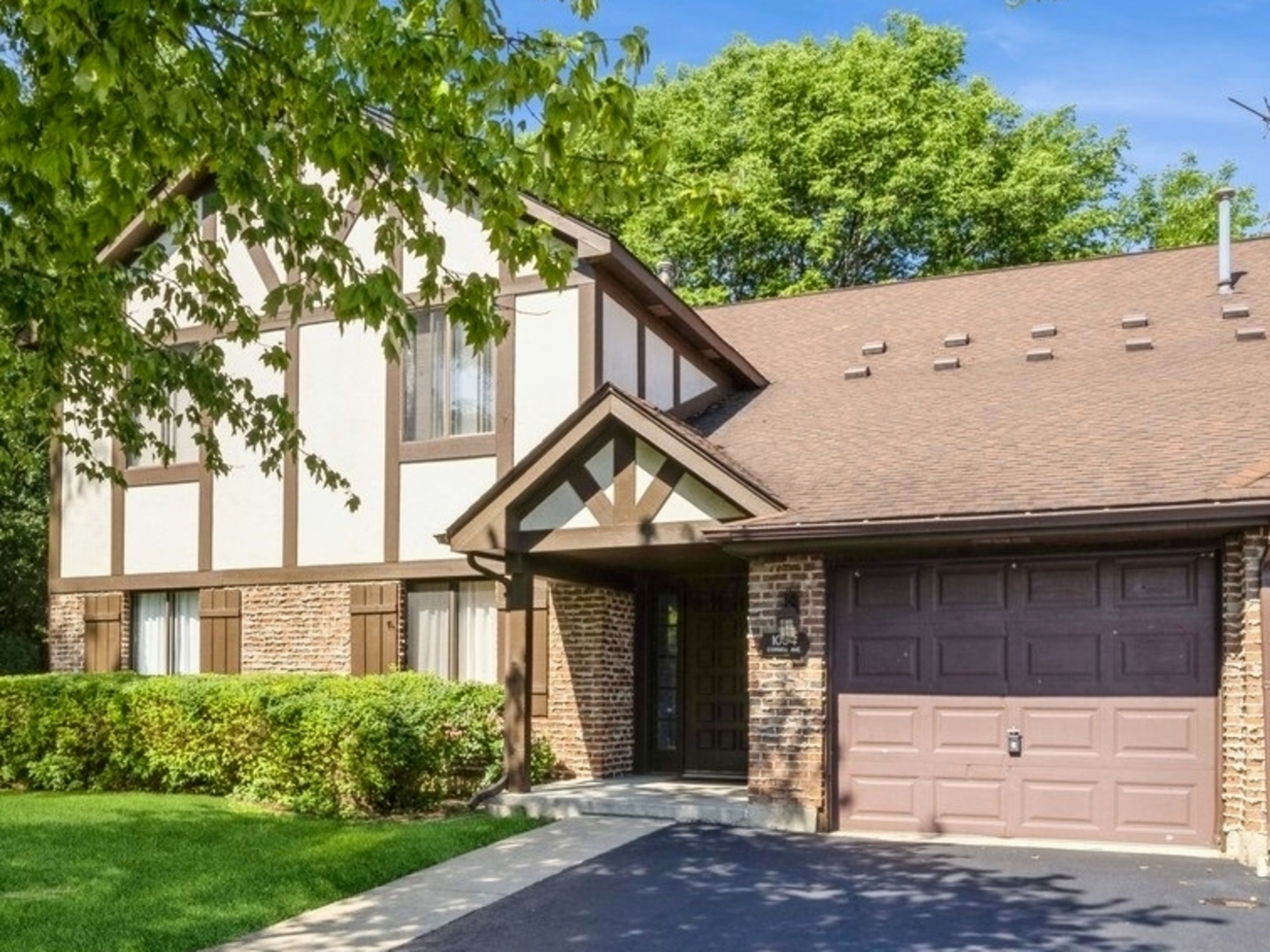 a view of a house with brick walls and a tree