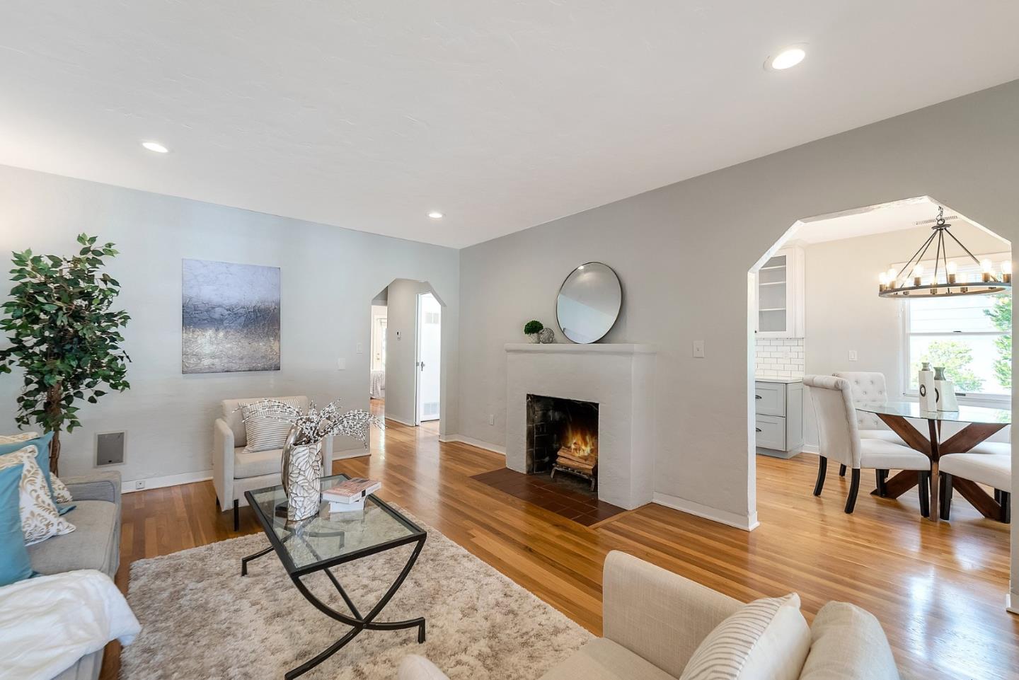 a living room with furniture a dining table and a fireplace