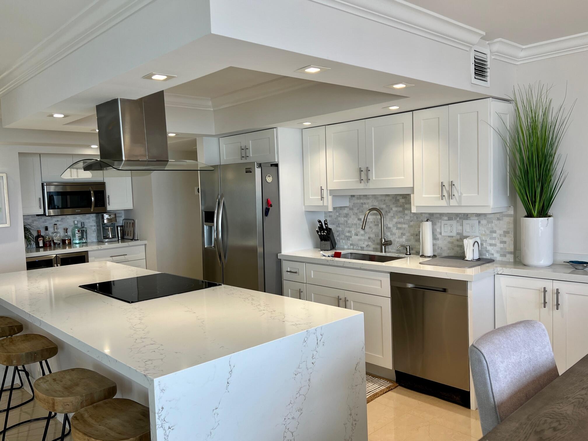 a kitchen with granite countertop a sink stainless steel appliances and white cabinets