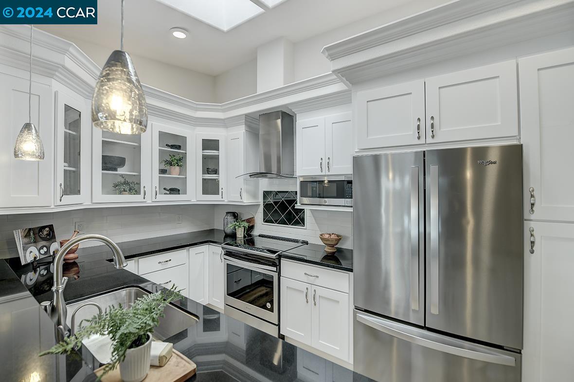 a kitchen with stainless steel appliances granite countertop a refrigerator sink and stove